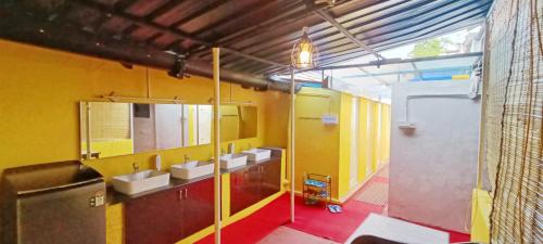 迈索尔xplorest的浴室设有三个水槽和黄色的墙壁