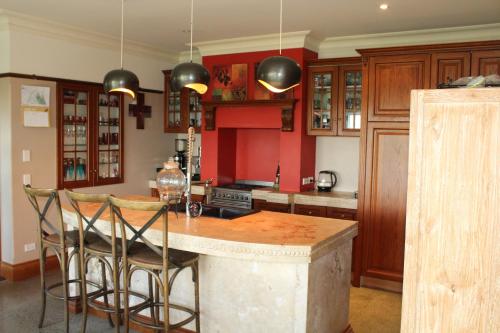 提马鲁Hadlow Sunrise Retreat的厨房拥有红色的墙壁,配有桌椅