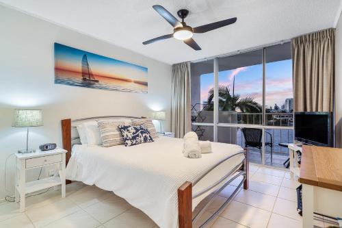 黄金海岸Amazing Water Views Surfers Paradise的一间卧室配有一张带吊扇的床和一个阳台