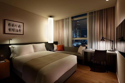 首尔驿三新罗舒泰酒店的酒店客房设有一张大床和一张沙发。