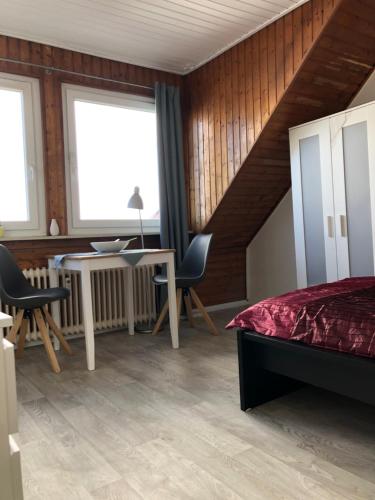 不莱梅East-Village-No5 Bremen的卧室配有一张床和一张桌子及椅子