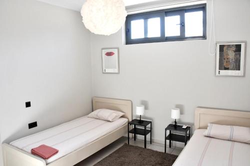 爱琴娜岛Polles Εlies Cozy Αpartment的一间卧室设有两张床和窗户。