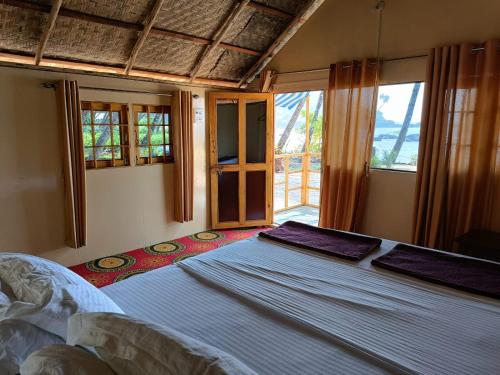 ColaCola Beach Sunset Bay的一间带一张大床的卧室,位于带窗户的房间内