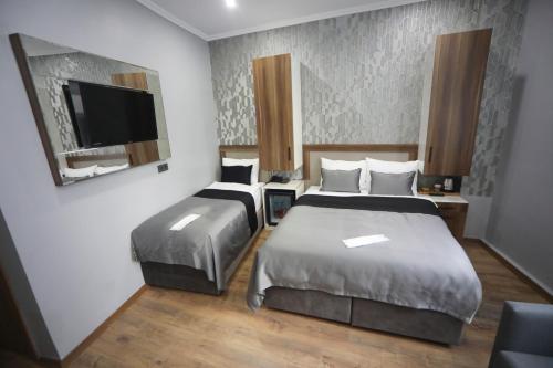 伊斯坦布尔Yuvam akmarmara hotel的酒店客房设有两张床和一台平面电视。