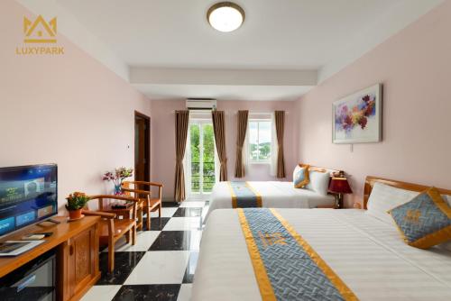 富国Luxy Park Hotel & Residences - Phu Quoc City Centre的一间酒店客房,设有两张床和电视