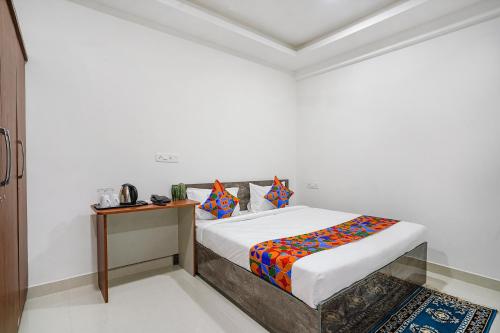 海得拉巴FabHotel Rooms 27的白色的客房配有一张床和一张桌子