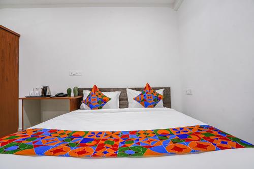 海得拉巴FabHotel Rooms 27的床上有五颜六色的毯子