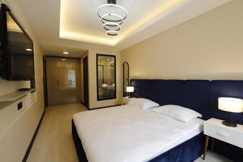 伊斯坦布尔Ravello Suites Taksim的一间卧室配有一张白色大床和蓝色的墙壁