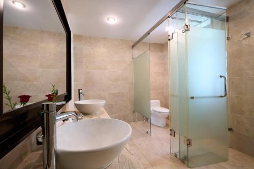 朗姑村兰珂海滩度假酒店的一间带两个水槽和玻璃淋浴间的浴室