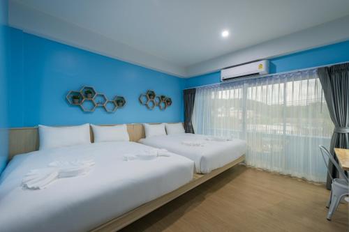甲米镇Otter House Aonang Intersection的一间卧室设有两张床和蓝色的墙壁
