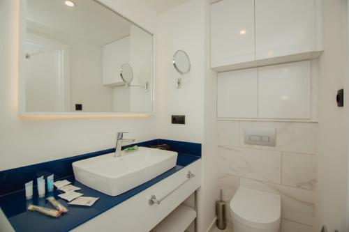 巴统Orbi City Central Aparthotel的白色的浴室设有水槽和卫生间。