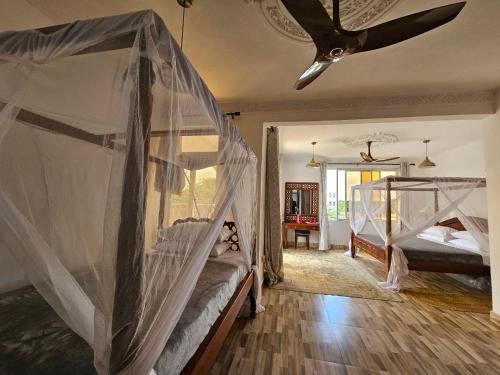 拉穆Ras Kitao Holiday Villa的一间卧室设有两张双层床和天花板