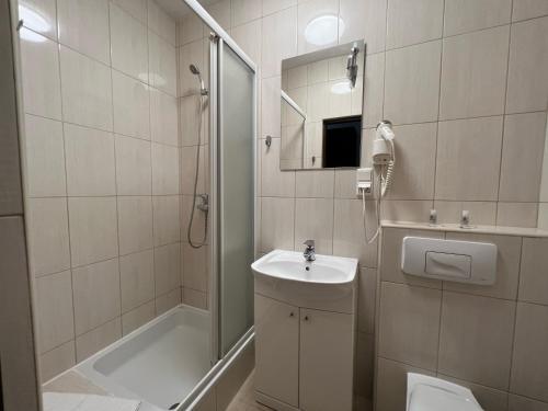 华沙姆鲁福卡会议中心公寓式酒店的一间带水槽、淋浴和卫生间的浴室