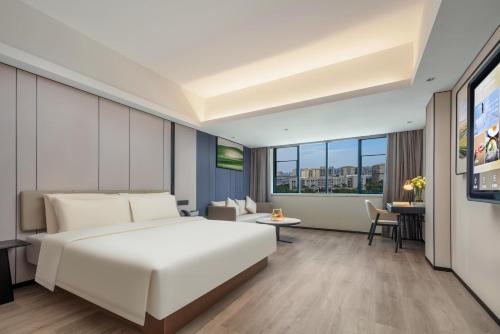 厦门厦门SM广场区政府亚朵X酒店的一间酒店客房,配有白色的床和电视