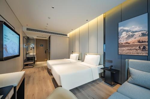 上海上海华泾亚朵酒店的客房设有2张白色的床和平面电视。