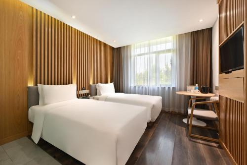北京北京三里屯农业展览馆亚朵X酒店的酒店客房设有两张床和电视。
