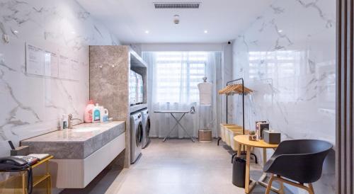 花都广州花都广场地铁站亚朵酒店的浴室设有水槽和带椅子的柜台。