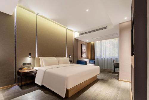 绍兴绍兴柯桥亚朵酒店的卧室配有一张白色大床和一张书桌