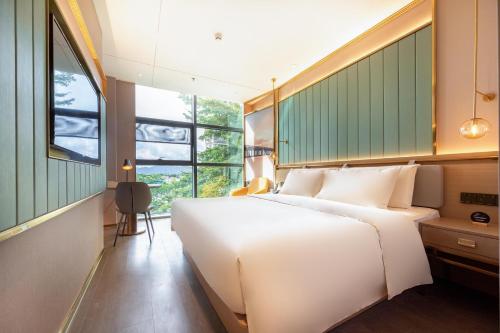 深圳深圳南山深圳湾亚朵轻居酒店的卧室设有一张白色大床和一扇窗户。