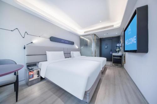 深圳深圳南山南油西地铁站轻居酒店的卧室配有一张白色大床和一台平面电视。
