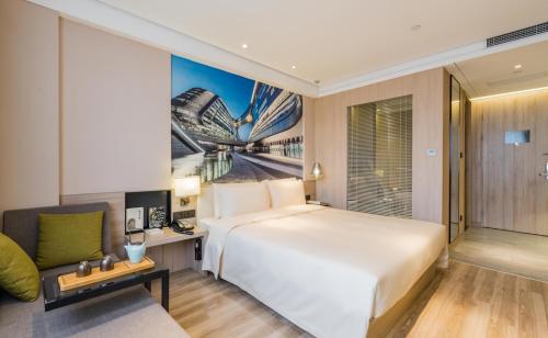 上海上海虹桥国展吴中路亚朵酒店的酒店客房设有一张大床和一张沙发。
