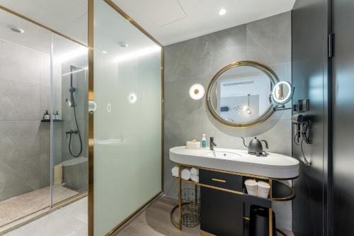 上海上海徐家汇交大轻居酒店的一间带水槽、淋浴和镜子的浴室