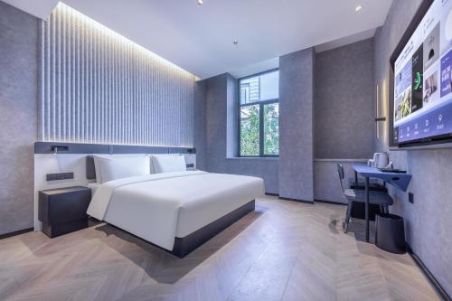 福州福州三坊七巷轻居酒店的卧室配有一张白色大床和一张书桌