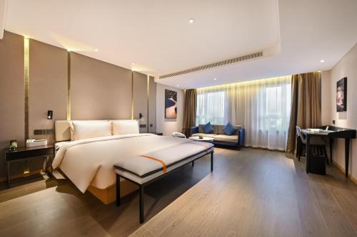 沈阳沈阳南塔文化路亚朵酒店的一间大卧室,配有一张大床和一张书桌