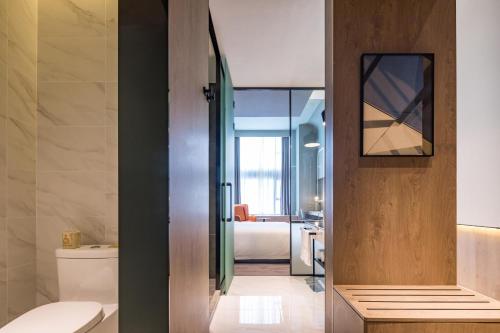 上海上海虹桥中心爱琴海亚朵S酒店的一间带卫生间的浴室和一间带床的房间