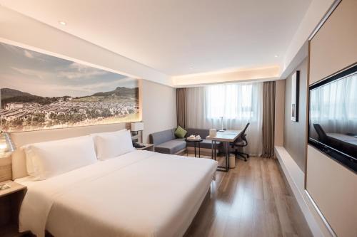 重庆重庆沙坪坝高铁站三峡广场亚朵酒店的酒店客房设有一张大床和一张书桌。