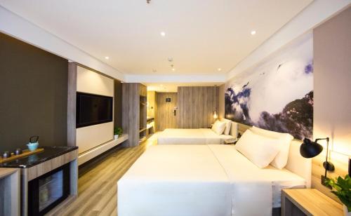 沈阳沈阳奥体营盘街地铁站亚朵酒店的酒店客房设有两张床和一台平面电视。