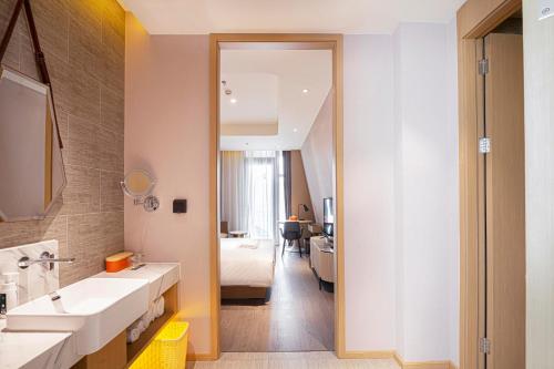 天津天津之眼亚朵酒店的一间带水槽、床和镜子的浴室