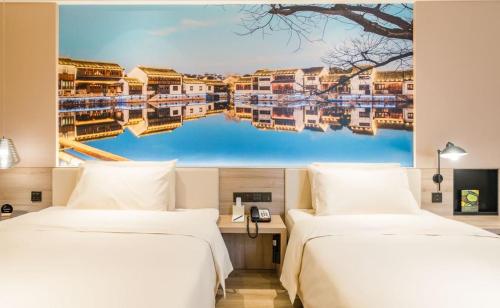 无锡无锡三阳广场亚朵酒店的墙上画画的房间里设有两张床