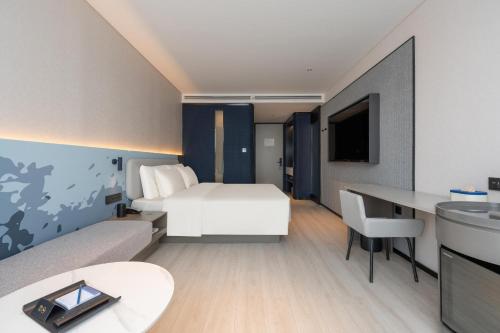 济南济南和谐广场省立医院轻居酒店的配有一张床和一张书桌的酒店客房
