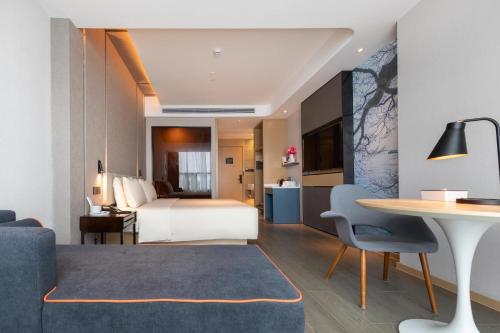 宝安深圳福海国际会展中心亚朵酒店的酒店客房配有一张床铺和一张桌子。