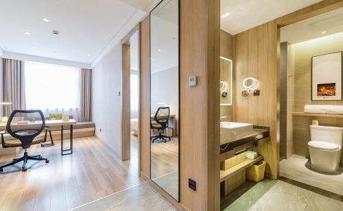 上海上海虹桥国展吴中路亚朵酒店的一间带水槽和卫生间的浴室以及一张书桌。
