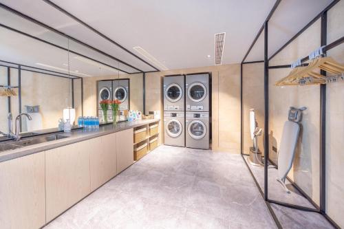 南京南京金马路地铁站亚朵酒店的洗衣房配有3台洗衣机和水槽