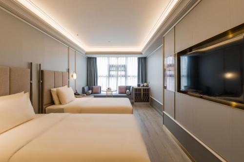 成都成都宽窄巷子亚朵酒店的酒店客房设有两张床和一台平面电视。