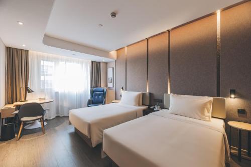 上海上海长宁仙霞路亚朵酒店的酒店客房配有两张床和一张书桌