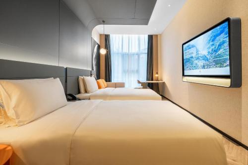 成都成都宽窄人民公园地铁站亚朵S酒店的酒店客房设有两张床和一台平面电视。