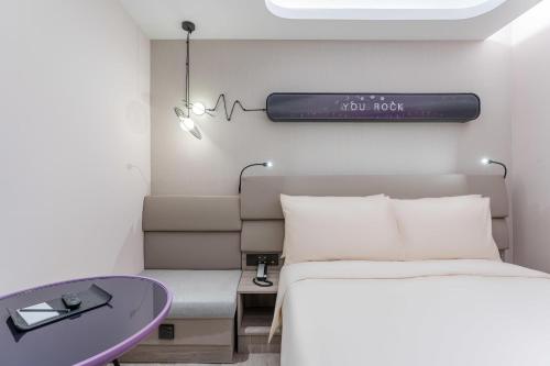 上海上海徐家汇交大轻居酒店的一间卧室配有一张床和一张紫色的桌子