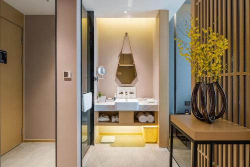 无锡无锡海岸城亚朵酒店的浴室设有水槽和黄色花瓶