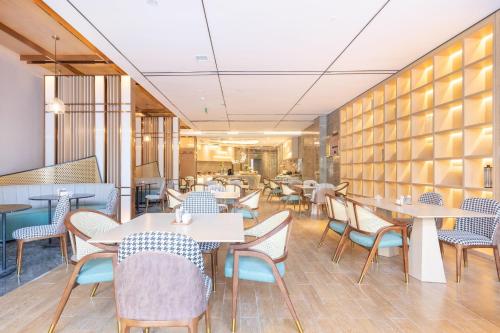 重庆重庆观音桥花卉园亚朵酒店的一间在房间内配有桌椅的餐厅
