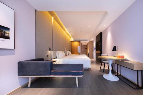 武汉武汉天地汉口江滩亚朵酒店的配有一张床和一张书桌的酒店客房