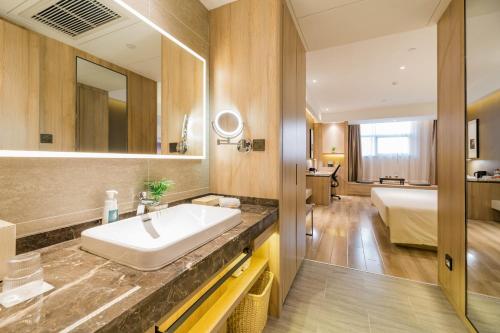 合肥合肥南站滨湖会展中心亚朵酒店的一间带水槽的浴室和一张位于客房内的床