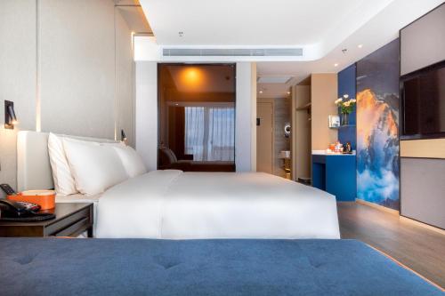 昆明昆明市政府春融街亚朵酒店的卧室配有一张白色大床和一张书桌