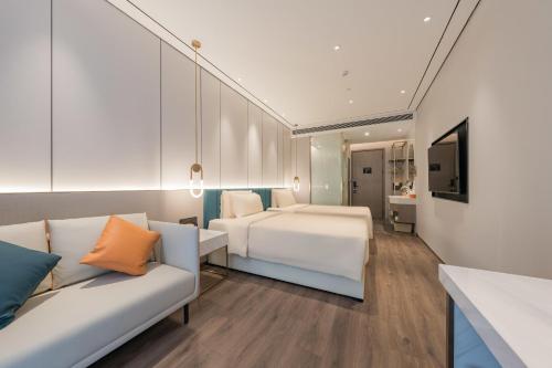 上海上海五角场INNO创智亚朵X酒店的酒店客房,设有两张床和一张沙发