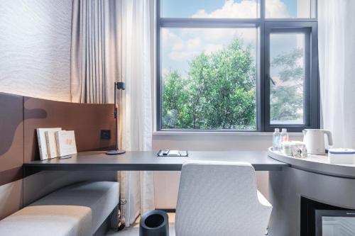 昆明昆明滇池路南亚风情第壹城轻居酒店的客房设有书桌和窗户。