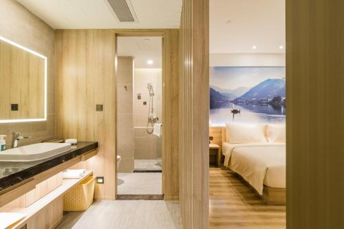 杭州杭州西湖文化广场地铁站上塘路亚朵酒店的一间带床、浴缸和水槽的浴室