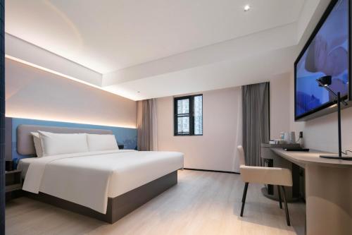 武汉武汉江滩江汉路步行街轻居酒店的配有一张床和一张书桌的酒店客房